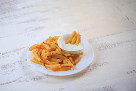 French fries on a table on a light table with sauce.の写真素材