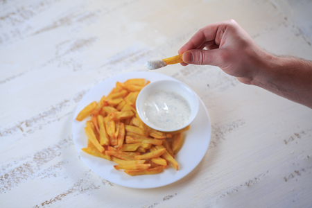 French fries on a table on a light table with sauce.の写真素材