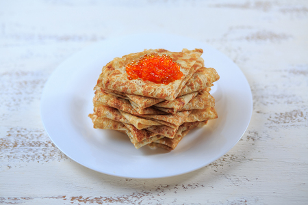 The Russian pancakes with a stuffing on a white plate on a light background. Maslenitsa.の写真素材