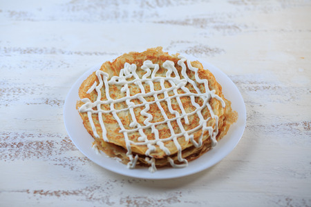 The Russian pancakes with a stuffing on a white plate on a light background. Maslenitsa.の写真素材