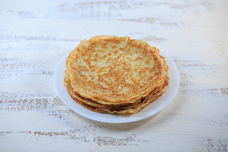 The Russian pancakes with a stuffing on a white plate on a light background. Maslenitsa.の写真素材