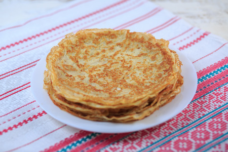The Russian pancakes with a stuffing on a white plate on a light background. Maslenitsa.の写真素材