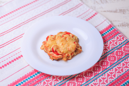 Small cheese and chicken pizza on a white plate on a table.の写真素材