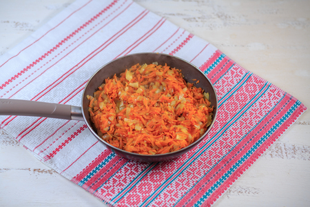 Stewed vegetables on a skorodka on a table. Carrots, tomato, onions.の写真素材