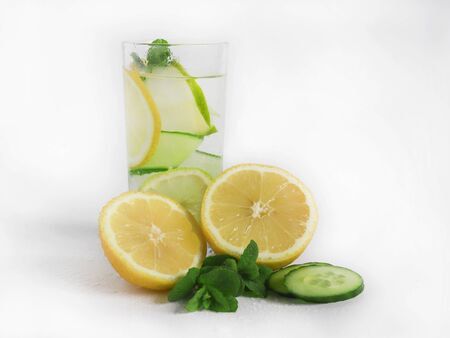 Chilled summer cocktail lemonade in a glass cup with ice, lemon, fresh cucumber and mint leaves. homemade lemonade to quench your thirst in the heat. selective focus.の写真素材