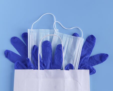 gloves ,mask on blue background. A typical surgical mask for covering the mouth and nose. The concept of protection against bacteria and viruses.の写真素材
