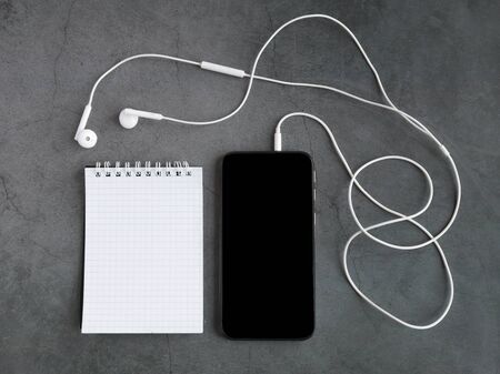 notepadmobile phone, and headphones on a gray background. View from above. Mock upの写真素材