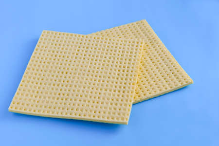 yellow sponges for washing dishes and other surfaces on a blue background. the concept of cleaning, cleaning, disinfection. close-upの写真素材