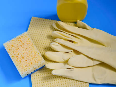 cleaning sponges of yellow color, latex gloves and means for cleaning the room and disinfection on a blue background, the concept of cleaning, surface disinfection. cleaning services.の写真素材
