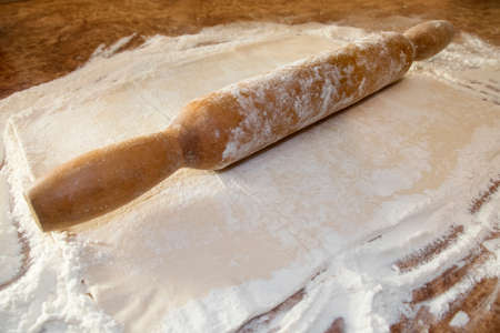 Rolling pin with dough on wooden background, Free space for text. pizza dough. flour and thawed doughの写真素材