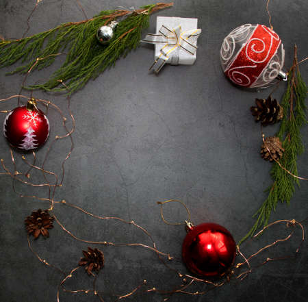 Christmas holidays composition with gift boxes on a background with pine cone, festive lights, red balls and juniper branches. View from above. Flatley, copyspaceの写真素材