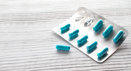 Bright pill capsules in a blister pack on a white background with space for advertising....