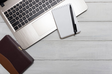 A workspace on a desktop is the main elements of a flat lay. White office desk with laptop, business...