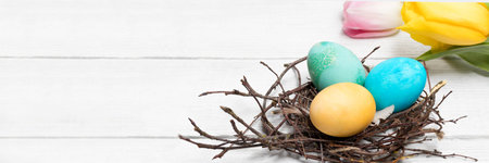 Happy Easter concept banner. Preparation for the holiday. Easter colored painted eggs in nests on a...