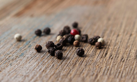 Mix of peppercornson a wooden background, on an old table close-up. Red, black, green and white dry...
