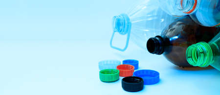 Plastic bottles and lids on a light background with space for text., Copy space. The concept of separate sorting of plastic, rejection of plastic, production of plastic bottles.の写真素材