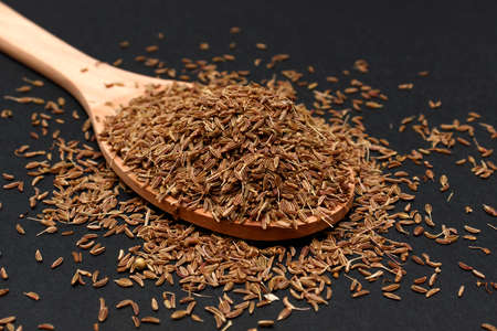 Cumin seeds or caraway in wooden spoon used as a spice. Aromatic Roman cumin, Dry cumin seedsの写真素材