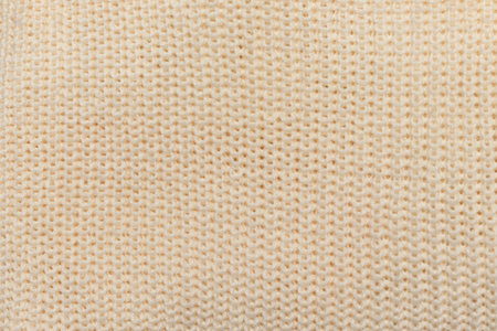 Close-up texture of knitted beige fabric, background for banner, site, postcard, wallpaper