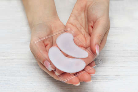 eye patches. Mask for moisturizing the skin around the eyes in female hands.の写真素材