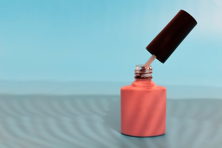 Bottle of nail polish on blue background with shadows. Beauty and fashion trendy concept.の写真素材