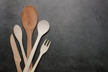 wooden kitchen utensils, home kitchen utensils on a dark background. View from above, copy space....