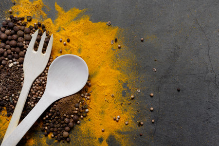 Spoon with fork on a background of spices. Space for text, copy space. The concept of cooking, recipes.の写真素材