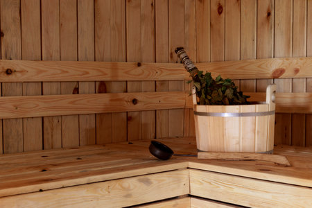Accessories for the sauna in the wooden sauna. Wooden tub, birch broom in hot steam. rest in spa or wellness center. Relaxation and recreation conceptの写真素材