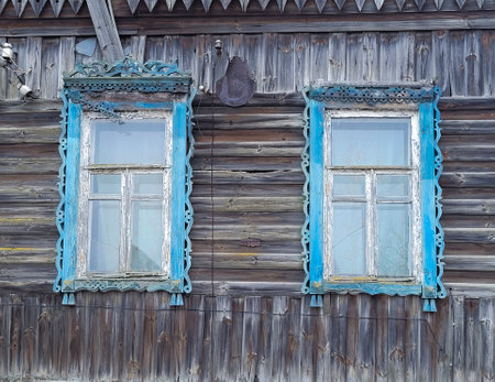 Old wooden windows with carved architravesの写真素材