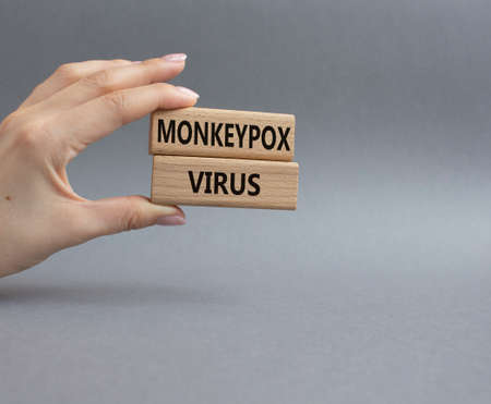 Monkeypox virus symbol. Concept word Monkeypox virus on wooden blocks. Beautiful grey background. Doctor Hand. Medicine and Monkeypox virus concept. Copy spaceの写真素材