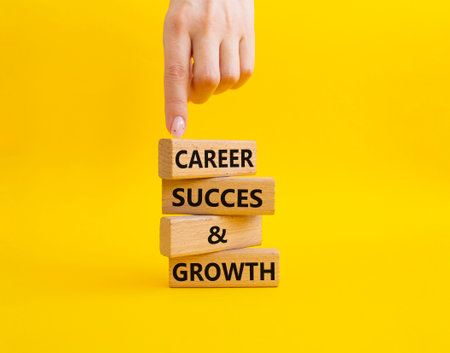 Career success and growth symbol. Wooden blocks with words Career success and growth. Beautiful yellow background. Businessman hand. Business and Career success and growth concept. Copy space.の写真素材