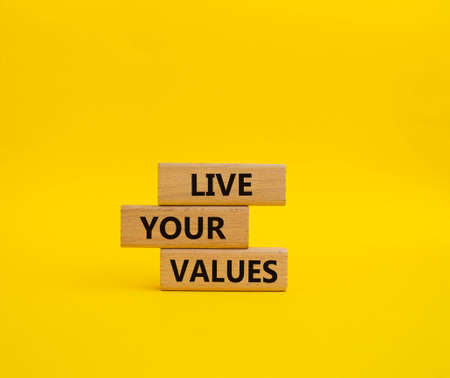 Live your values symbol. Concept words 'Live your values' on wooden blocks. Beautiful yellow background. Business and Live your values concept. Copy space.の写真素材