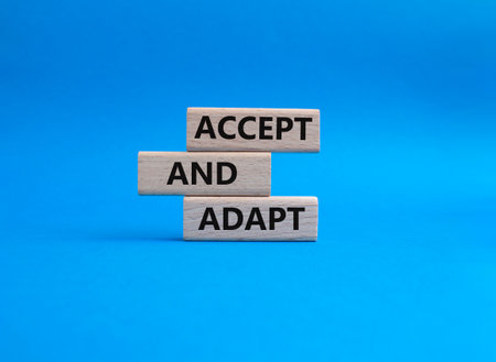 Accept or adapt symbol. Wooden blocks with words 'Accept and adapt'. Beautiful blue background. Business and 'Accept and adapt' concept. Copy space.の写真素材