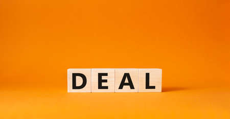 Deal symbol. Concept word Deal on wooden cubes. Beautiful orange background. Business and Deal concept. Copy space.の写真素材