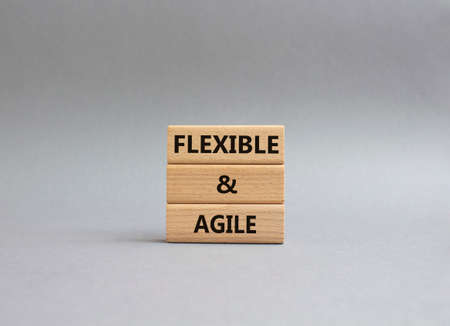 Flexible and agile symbol. Concept word Flexible and agile on wooden blocks. Beautiful grey background. Business and Flexible and agile concept. Copy spaceの写真素材