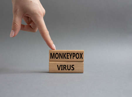 Monkeypox virus symbol. Concept word Monkeypox virus on wooden blocks. Beautiful grey background. Doctor Hand. Medicine and Monkeypox virus concept. Copy spaceの写真素材
