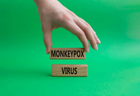 Monkeypox virus symbol. Concept word Monkeypox virus on wooden blocks. Beautiful green background. Doctor Hand. Medicine and Monkeypox virus concept. Copy spaceの写真素材