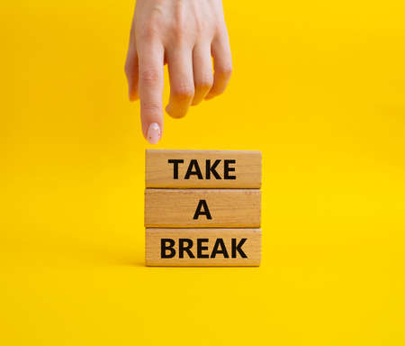 Take a break symbol. Concept words 'Take a break' on wooden blocks. Beautiful green background. Businessman hand. Business and Take a break concept. Copy space.の写真素材