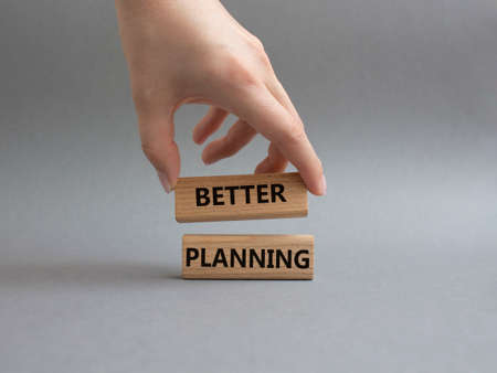 Better planning symbol. Concept word Better planning on wooden blocks. Beautiful grey background. Businessman hand. Business and Better planning concept. Copy spaceの写真素材