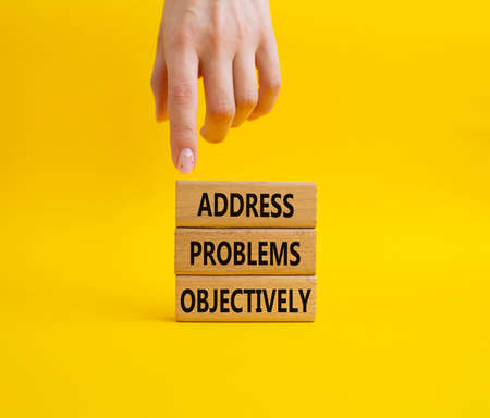 Address Problems Objectively symbol. Wooden blocks with words Address Problems Objectively. Beautiful yellow background. Businessman hand. Business and Address Problems Objectively concept. Copy space.の写真素材