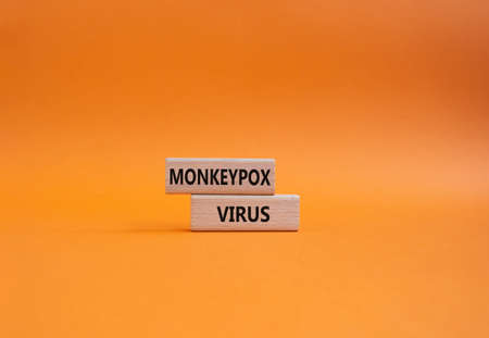 Monkeypox virus symbol. Concept word Monkeypox virus on wooden blocks. Beautiful orange background. Medicine and Monkeypox virus concept. Copy spaceの写真素材