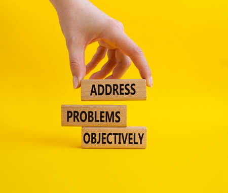 Address Problems Objectively symbol. Wooden blocks with words Address Problems Objectively. Beautiful yellow background. Businessman hand. Business and Address Problems Objectively concept. Copy space.の写真素材