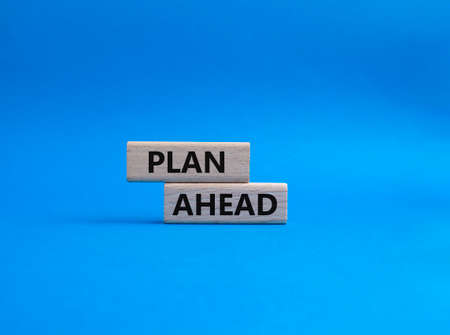 Plan ahead symbol. Wooden blocks with words Plan ahead. Beautiful blue background. Business and 'Plan ahead' concept. Copy space.の写真素材