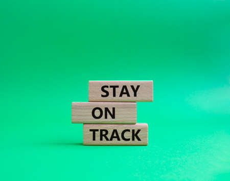 Stay on track symbol. Wooden blocks with words 'Stay on track'. Beautiful green background. Business and 'Stay on track' concept. Copy space.の写真素材
