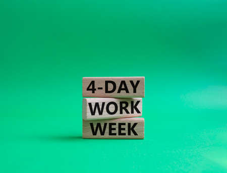 4-day work week symbol. Concept words 4-day work week on wooden blocks. Beautiful green background. Business and 4-day work week concept. Copy spaceの写真素材