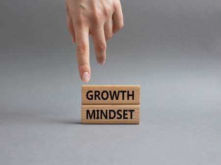 Growth Mindset symbol. Concept word Growth Mindset on wooden blocks. Beautiful grey background. Businessman hand. Business and Growth Mindset concept. Copy spaceの写真素材
