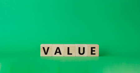 Value symbol. Concept word value on wooden cubes. Beautiful green background. Business and value concept. Copy space.の写真素材