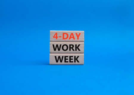 4-day work week symbol. Concept words 4-day work week on wooden blocks. Beautiful blue background. Business and 4-day work week concept. Copy spaceの写真素材