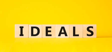 Ideals symbol. Wooden blocks with word Ideals. Beautiful yellow background. Business and Ideals concept. Copy space.の写真素材