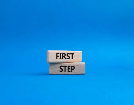 First step symbol. Wooden blocks with words 'First step'. Beautiful blue background. Business and 'First step' concept. Copy space.の写真素材