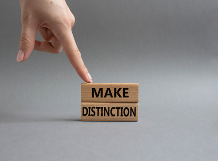 Make distinction symbol. Concept words make distinction on wooden blocks. Beautiful grey background....